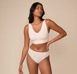 Full-body view of Victoria wearing the Bliss Bralette and the Cloud Cotton Thong in Quartz. Victoria wears the Bliss Bralette and coordinating bottoms in Quartz. The look emphasizes effortless comfort and clean lines designed for real bodies.