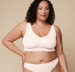 Front view of Bianca wearing the Bliss Bralette in Quartz. Bianca wears the Bliss Bralette in Quartz, showcasing the flattering neckline, wide straps, and ultra-smooth finish. sizing: Bianca wears size XL