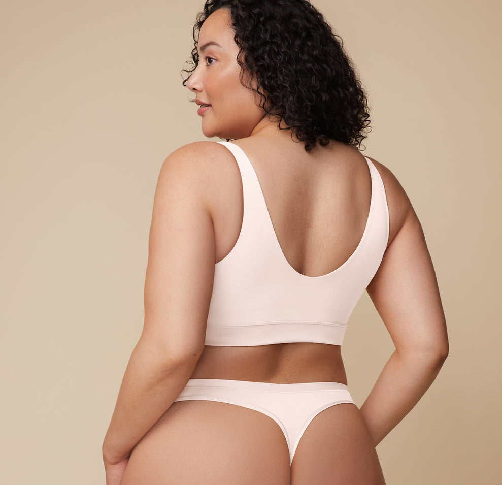 Back view of Bianca wearing the Bliss Bralette in Quartz with the Cloud Cotton Thong. The scoop back and minimal seam construction offer both style and second-skin comfort.