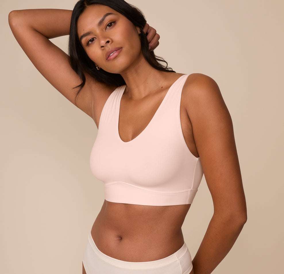 Three-quarter angle of Victoria wearing the Bliss Bralette in Rose. Her relaxed pose highlights the lightly lined cups and second-skin feel.