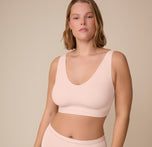 Front view of Sonnie wearing the Bliss Bralette in Rose. The bralette contours to her curves with minimal seams and a flattering, deep V neckline. sizing: Sonnie wears size XL