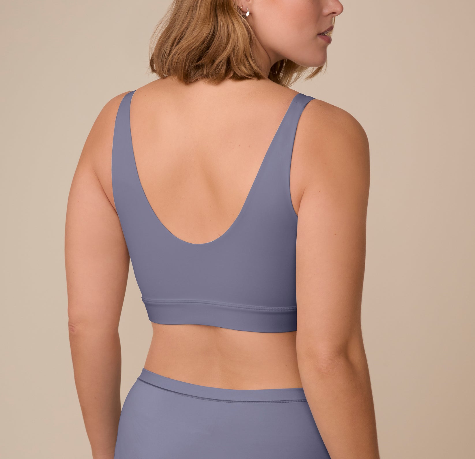 Back view of Sonnie wearing the Bliss Bralette in Steel. The scoop back lays flat against the skin, offering wire-free comfort that moves with you.