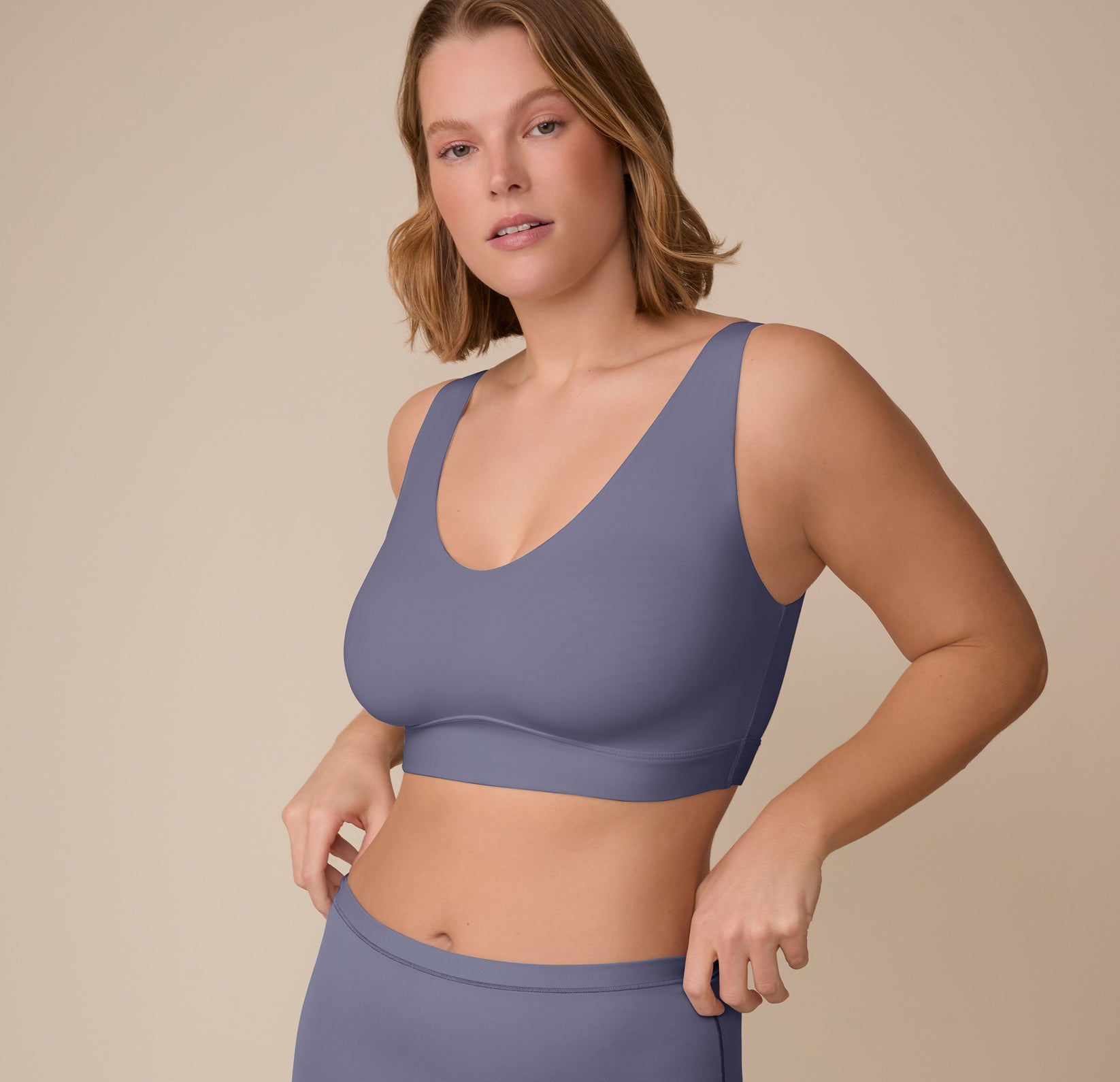 Three-quarter angle of Sonnie in the Bliss Bralette in Steel. Her relaxed pose shows the bralette’s clean lines and flexible fit.