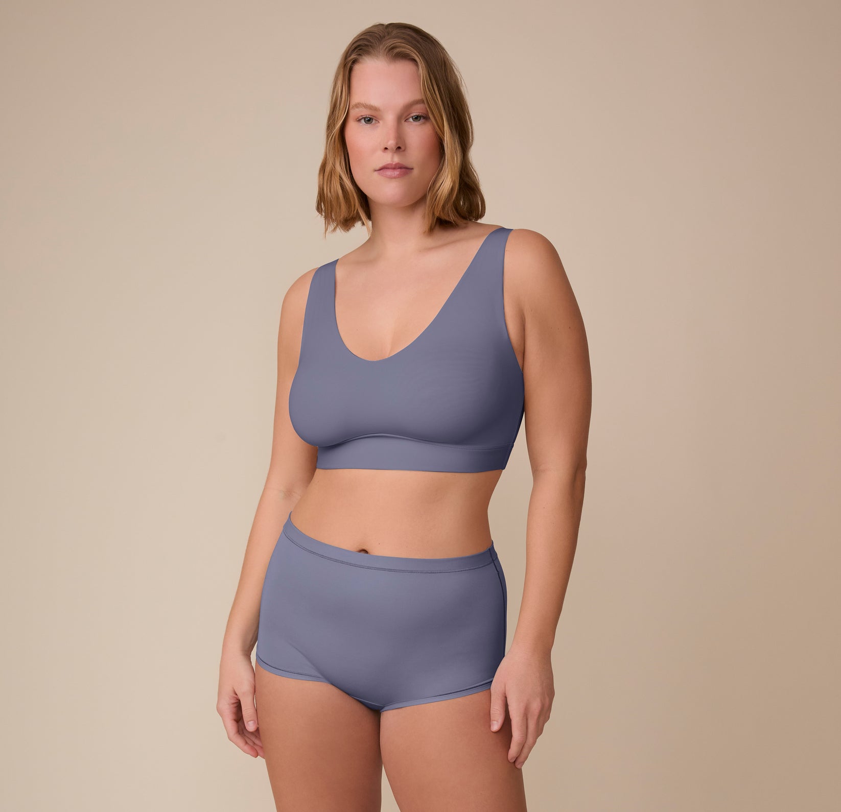 Full body view of Sonnie in the Bliss Bralette and matching Bliss Highwaist Boyshort in Steel. The soft blue-grey tone offers a calming, elevated everyday look.