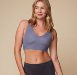Front view of Megan wearing the Bliss Bralette in Steel. The supportive fit and clean neckline offer comfort and confidence in a muted blue hue. sizing: Megan wears sizes Medium