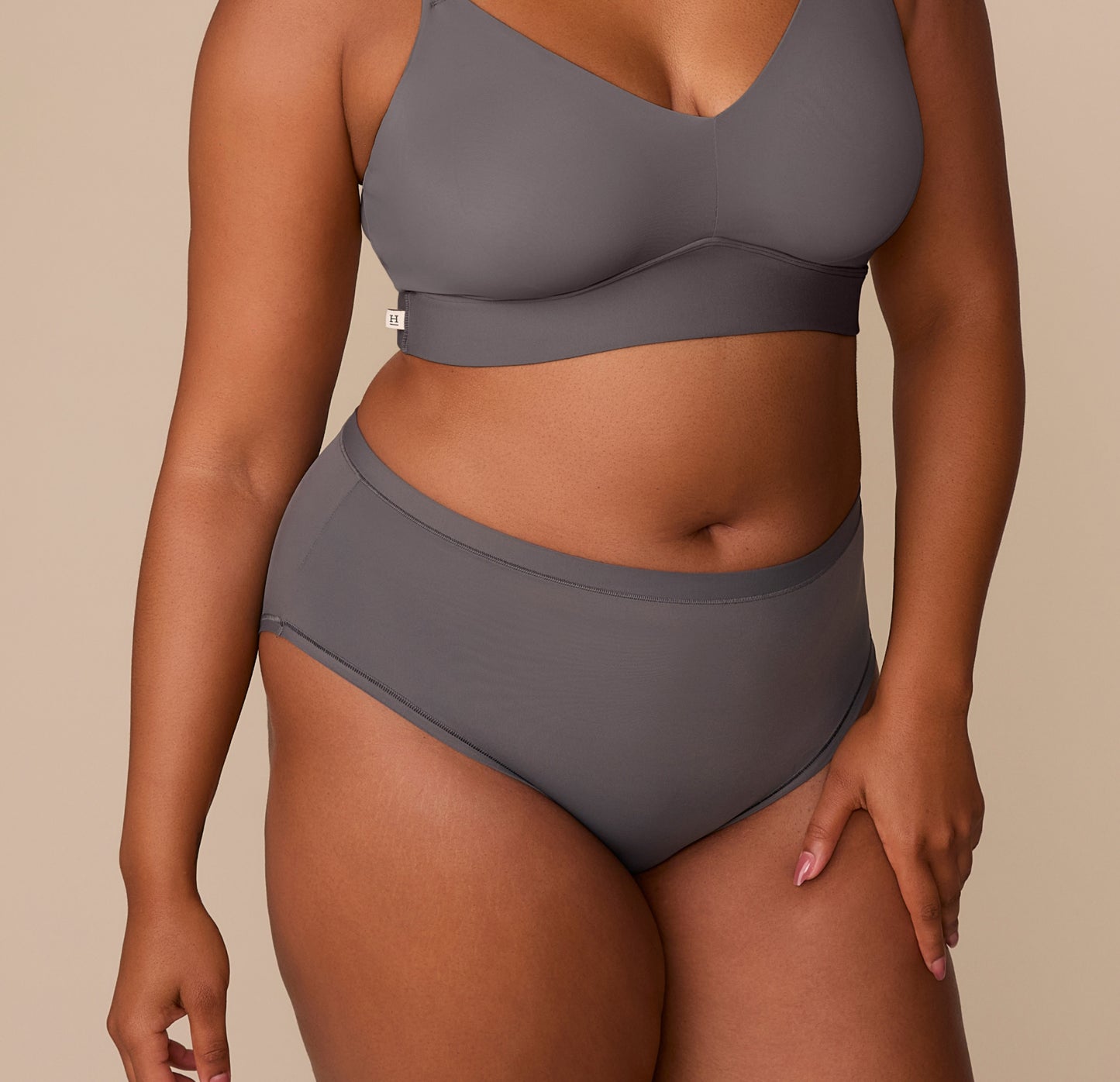 Front view of Zarria wearing the Bliss Highwaist Brief in Smoke. The brief offers a mid-rise fit with fuller coverage and no elastic for a smooth, comfortable feel. sizing: Zarria wears size XL