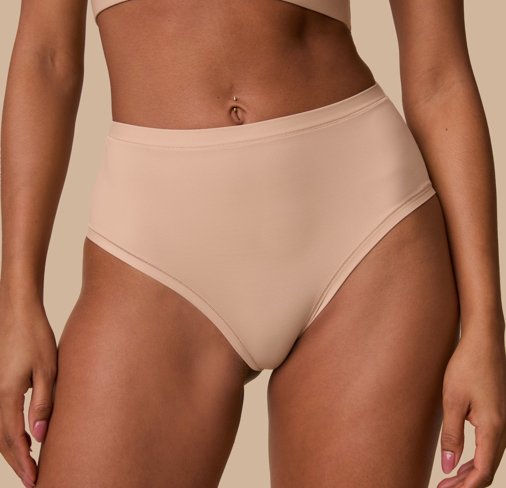 A close-up of Ally wearing the Bliss Highwaist Brief in Beige, emphasizing the soft waistband and minimal construction designed for ultimate comfort.