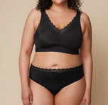 Front view of Bianca in the Bliss Lace Highwaist Brief in Black, featuring a soft, high-rise fit with a delicate lace waistband for a stylish yet comfortable feel. sizing: Bianca wears size XL