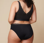Back view of Bianca wearing the Bliss Lace Highwaist Brief in Black. The full-coverage design and ultra-soft lace trim provide a smooth, comfortable fit.