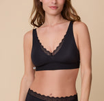 A close-up of Gracie wearing the Bliss Lace Bralette in Black. The deep V-neckline is trimmed with delicate lace, highlighting the bralette’s soft and seamless design. sizing: Gracie wears size Small