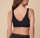 A back view of Gracie wearing the Bliss Lace Bralette in Black, showcasing the deep V-back lace trim and wide, supportive straps.