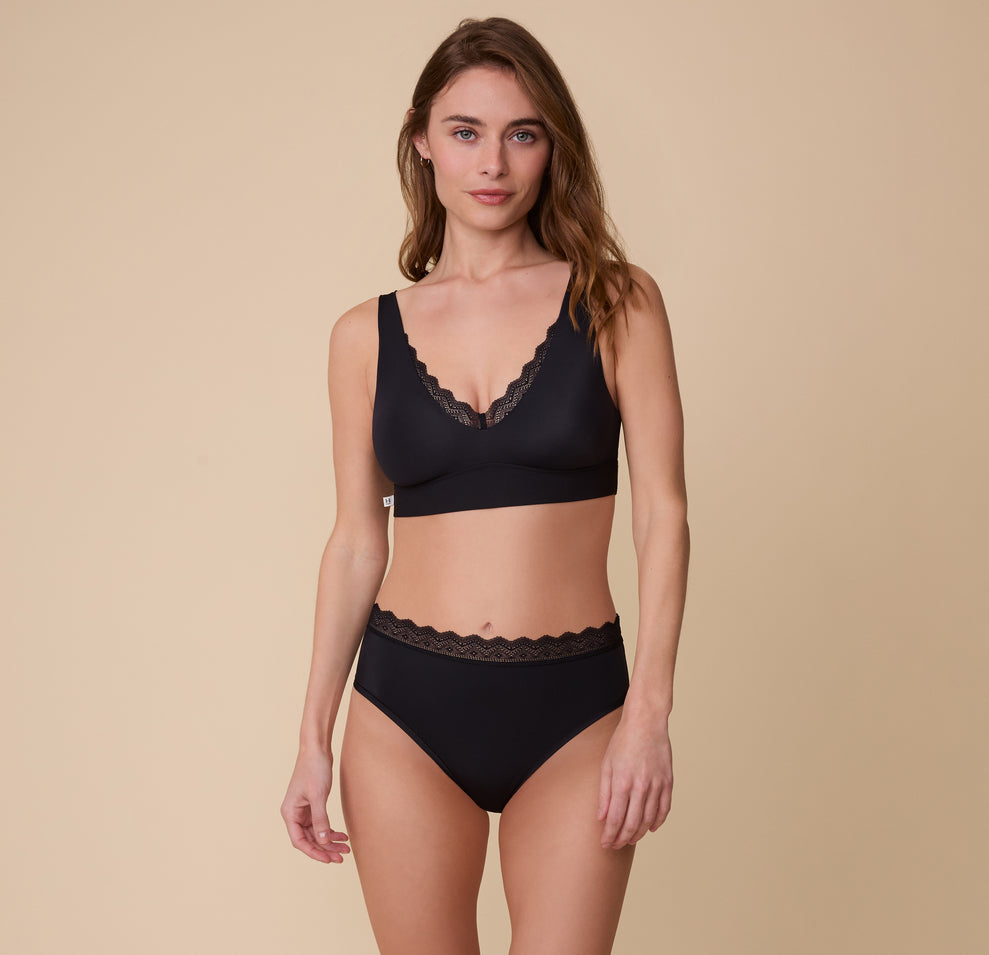 Gracie poses in the Bliss Lace Bralette in Black with the matching Bliss Lace Highwaist Brief. The image highlights the full set, emphasizing comfort and everyday wearability.