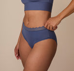 Three quarter profile of Nemesis wearing the Bliss Lace Highwaist Brief in Twilight. The stretch waistband sits comfortably at the waist, offering light smoothing with a flexible fit.
