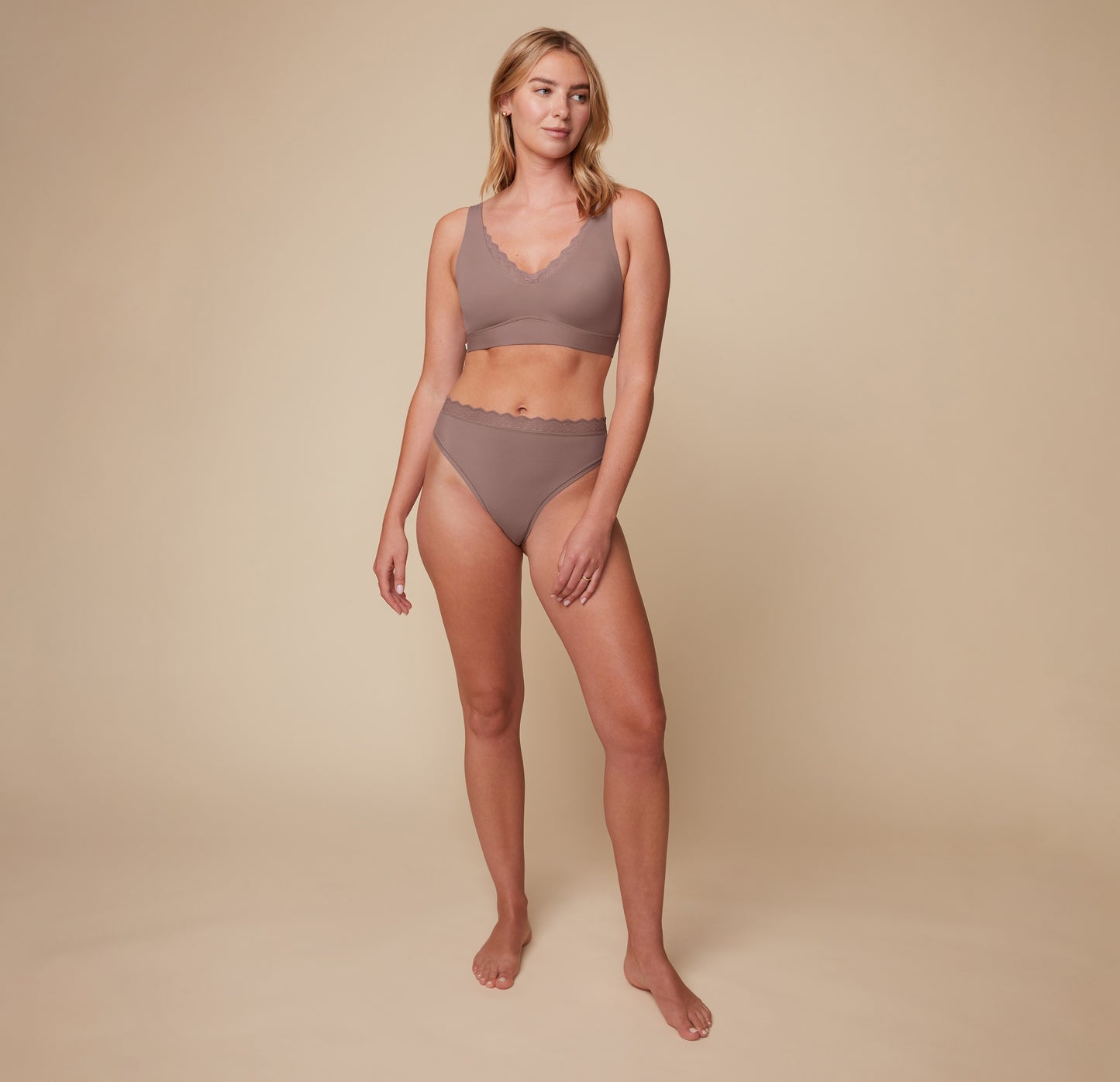 Model Megan wearing the Bliss Lace Thong in Mauve, paired with the matching Bliss Lace Halterneck Bralette. She stands facing forward, highlighting the soft fit of the lace thong and the supportive halterneck bralette.