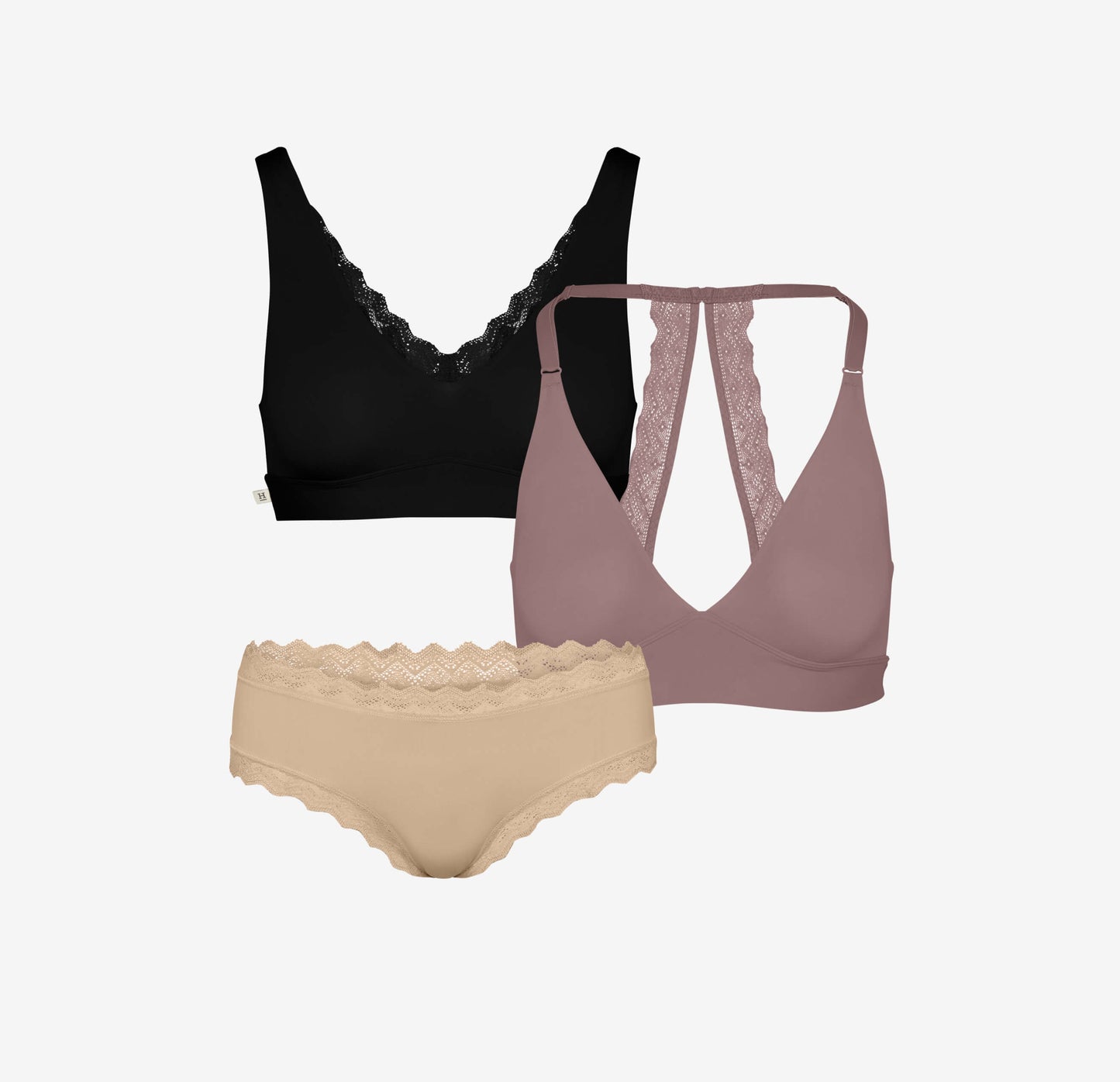 Product flat lay featuring Bliss Lace Bralette in black, Bliss Lace Halterneck Bralette in mauve, and Bliss Lace Cheeky in beige. All styles showcase delicate lace detailing.