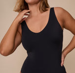 Close-up of Sonnie in the Bliss Plunge Bodysuit in Black, focusing on the deep scoop neckline and smooth microfiber fabric that hugs the body.