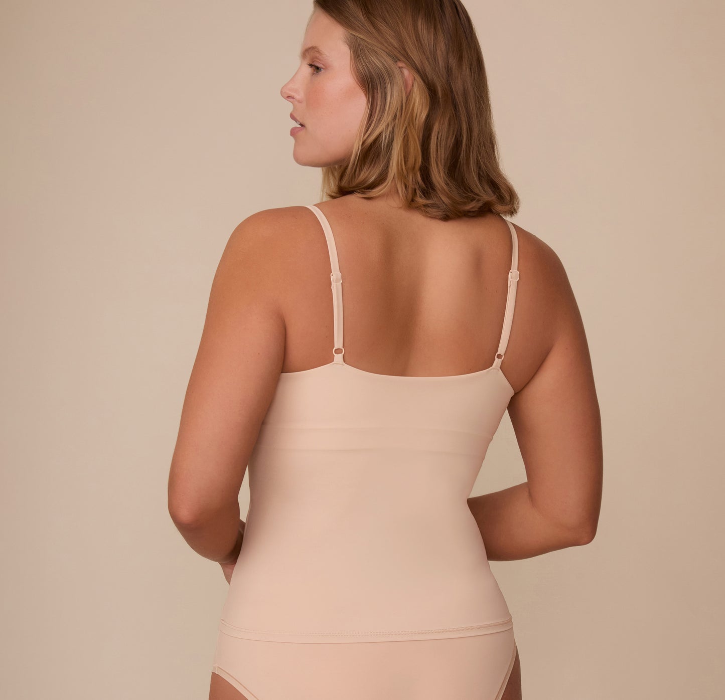 Back view of Sonnie in the Bliss Cami in Beige. The image highlights the cami’s clean backline and adjustable straps for a customizable fit.