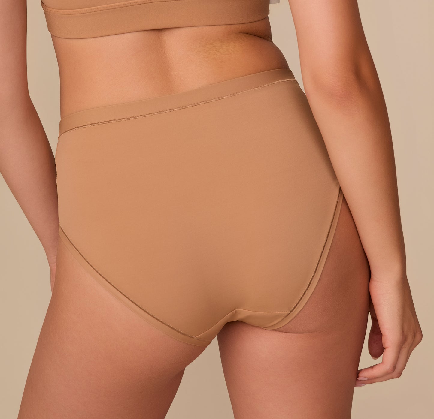 Detailed back angle of the Bliss Highwaist Brief in Tan, emphasizing the comfortable coverage and seamless construction.