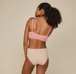 Back view of Zoe standing upright, hands resting casually at her sides, in the Bliss Scoop Bralette and Bliss Highwaist Brief, highlighting the adjustable straps of the bralette.