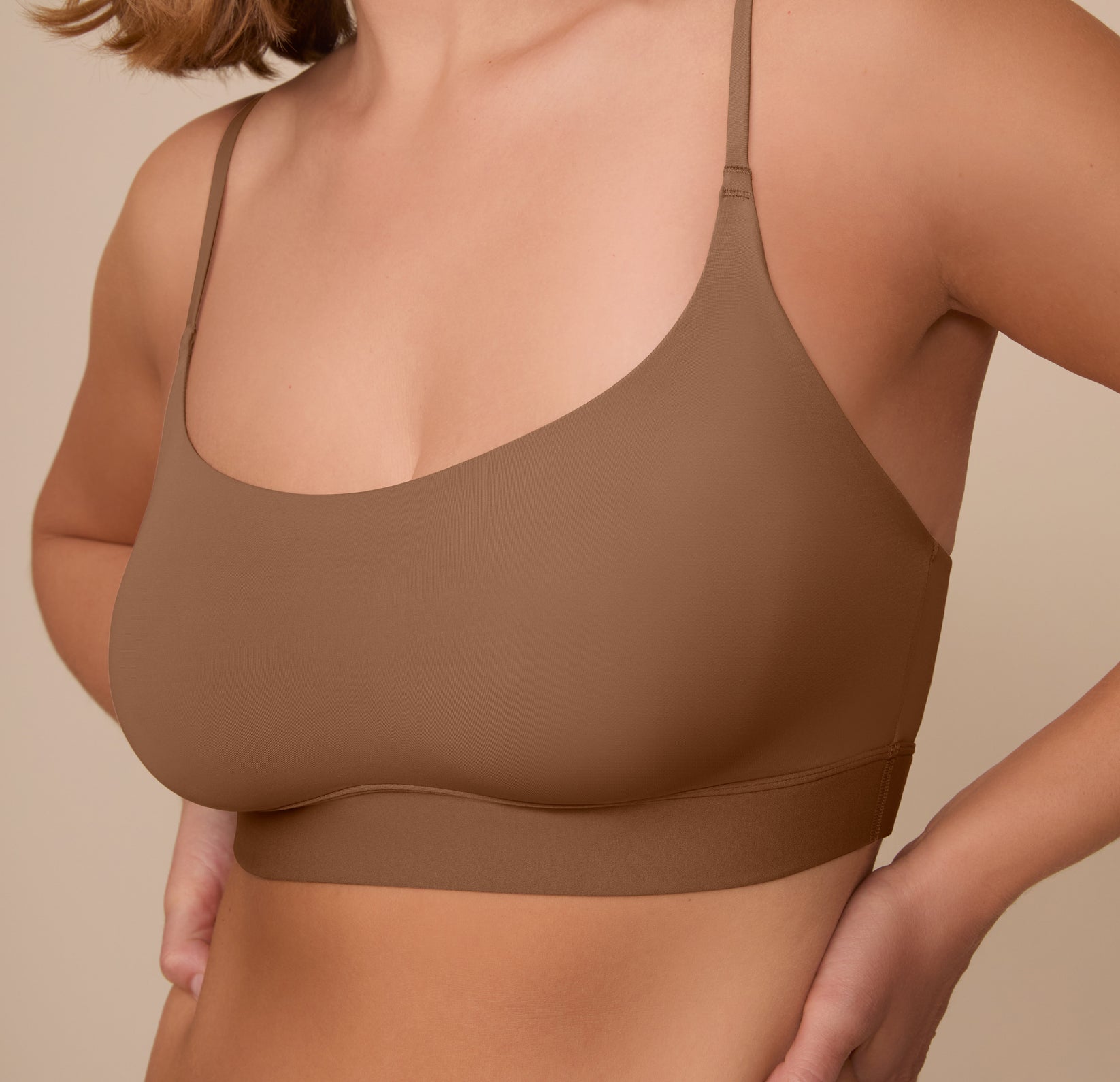 Close up view of Sonnie facing forward in the Bliss Scoop Bralette in Brown. The comfort seams and thin straps are highlighted.