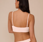 Back view of Marcela in the Bliss Scoop Bralette in Rose, highlighting the minimalist design and flexible fit of the back band.