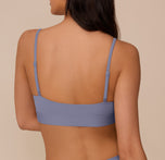 Back view of Marcela in the Bliss Scoop Bralette in Steel, highlighting the minimalist design and flexible fit of the bralette's back band.