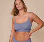 Front view of Sonnie wearing the Bliss Scoop Bralette in Steel. The scoop neckline and wide underband provide a supportive fit with a sleek silhouette. sizing: Sonnie wears size XL