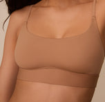 Up close shot of Marcela in the Bliss Scoop Bralette in Tan, showing the gentle scoop neckline and wide underband for comfort.