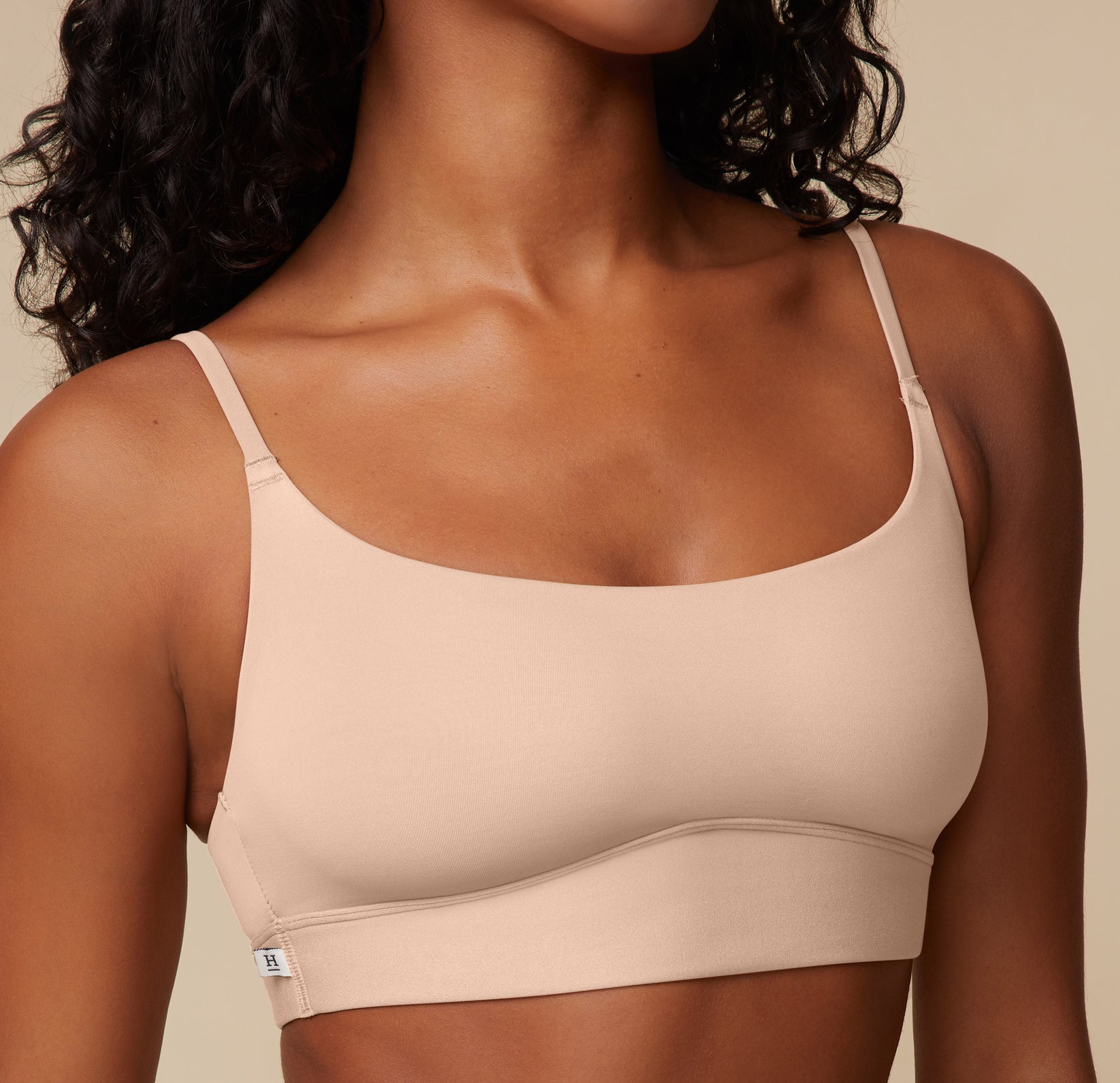 Close-up of the front neckline and fabric texture of the Bliss Scoop Bralette in Beige, worn by Ally. Emphasizes the softness and smooth construction.