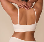 Back view of Zarria wearing the Bliss Scoop Bralette in Quartz. Rear view of Zarria in the Bliss Scoop Bralette in Quartz. The wide underband offers secure support, and the adjustable straps ensure a customizable fit.