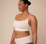 Three quarter profile of Zarria wearing the Bliss Scoop Bralette in Quartz. The image highlights the clean side seams and the sleek, minimal silhouette of the bralette.