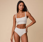 Full-body shot of Ally wearing the Bliss Square Neck Bralette and matching Highwaist Brief in Frost. The image captures the set’s minimalist design and second-skin softness.