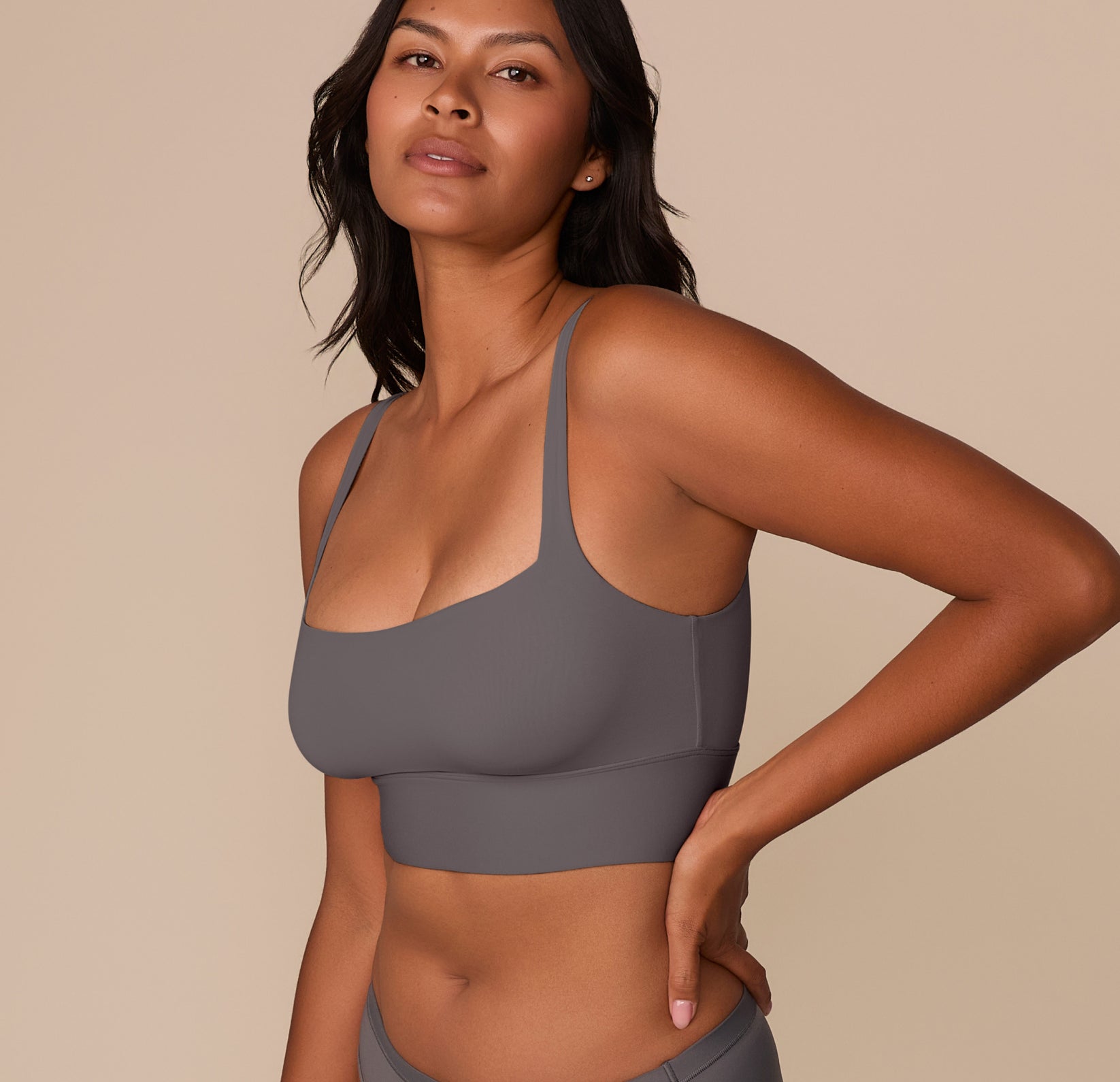 Side angle of Victoria modeling the Bliss Square Neck Bralette in Smoke, emphasizing the sleek lines and flexible, supportive structure.