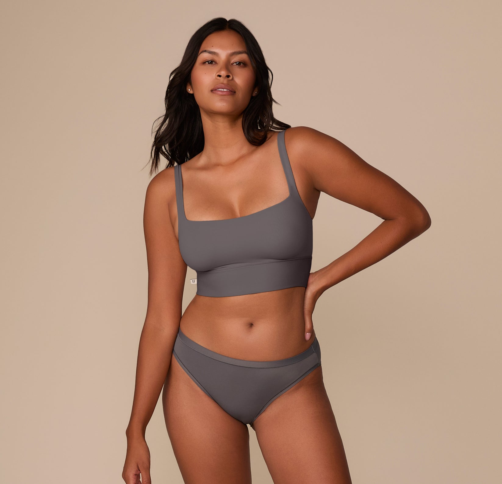 Full body image of Victoria wearing the Bliss Square Neck Bralette with the Bliss Bikini in Smoke. The matching set is shown from the front to highlight its streamlined silhouette.