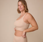 Sonnie stands at an angle, smiling slightly while showcasing the Bliss Square Neck Bralette's smooth, supportive fit with its longline band and squared-off neckline.