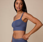 Three quarter profile of Nemesis modeling the Bliss Square Neck Bralette in Twilight. The bralette’s clean lines and supportive underband are clearly visible.