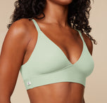 Close-up of Ally wearing the Bliss Triangle Bralette in Dew. The shot focuses on the double-layer fabric, wide underband, and signature H logo tag at the side.