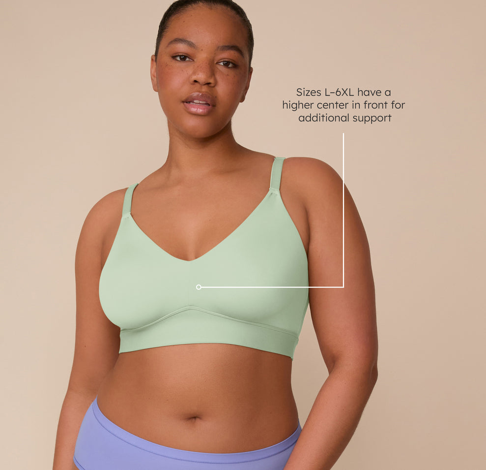 Front view of Zarria modeling the Bliss Triangle Bralette in Dew. A text callout notes that sizes L–6XL have a higher center front for added support. sizing: Zarria wears size 2XL