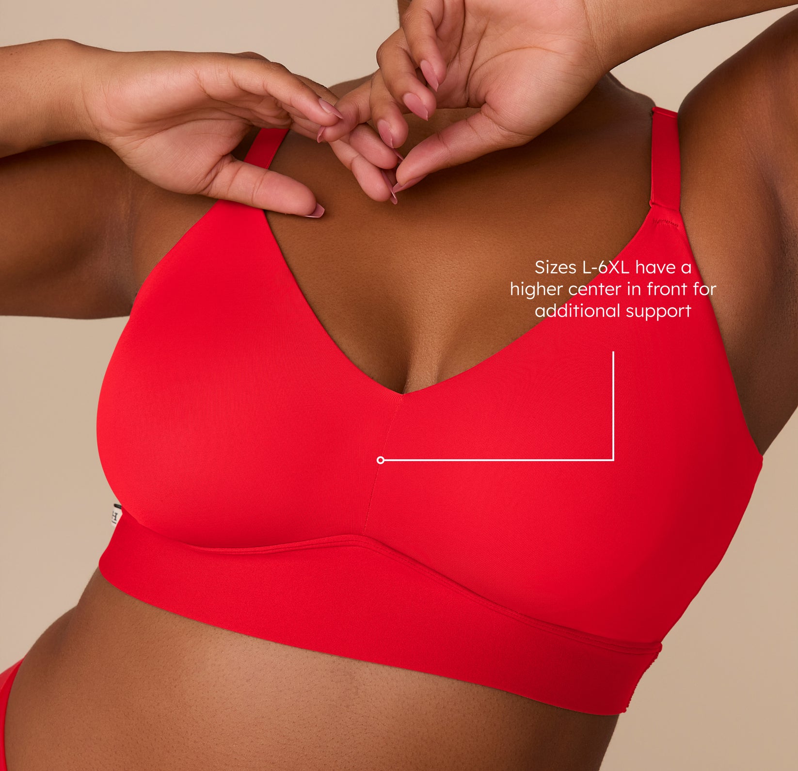 Detail shot of the Bliss Triangle Bralette in Cherry worn by Zarria, featuring a callout note that sizes L–6XL have a higher center  in front for additional support. The image highlights the bralette’s fit and construction.
