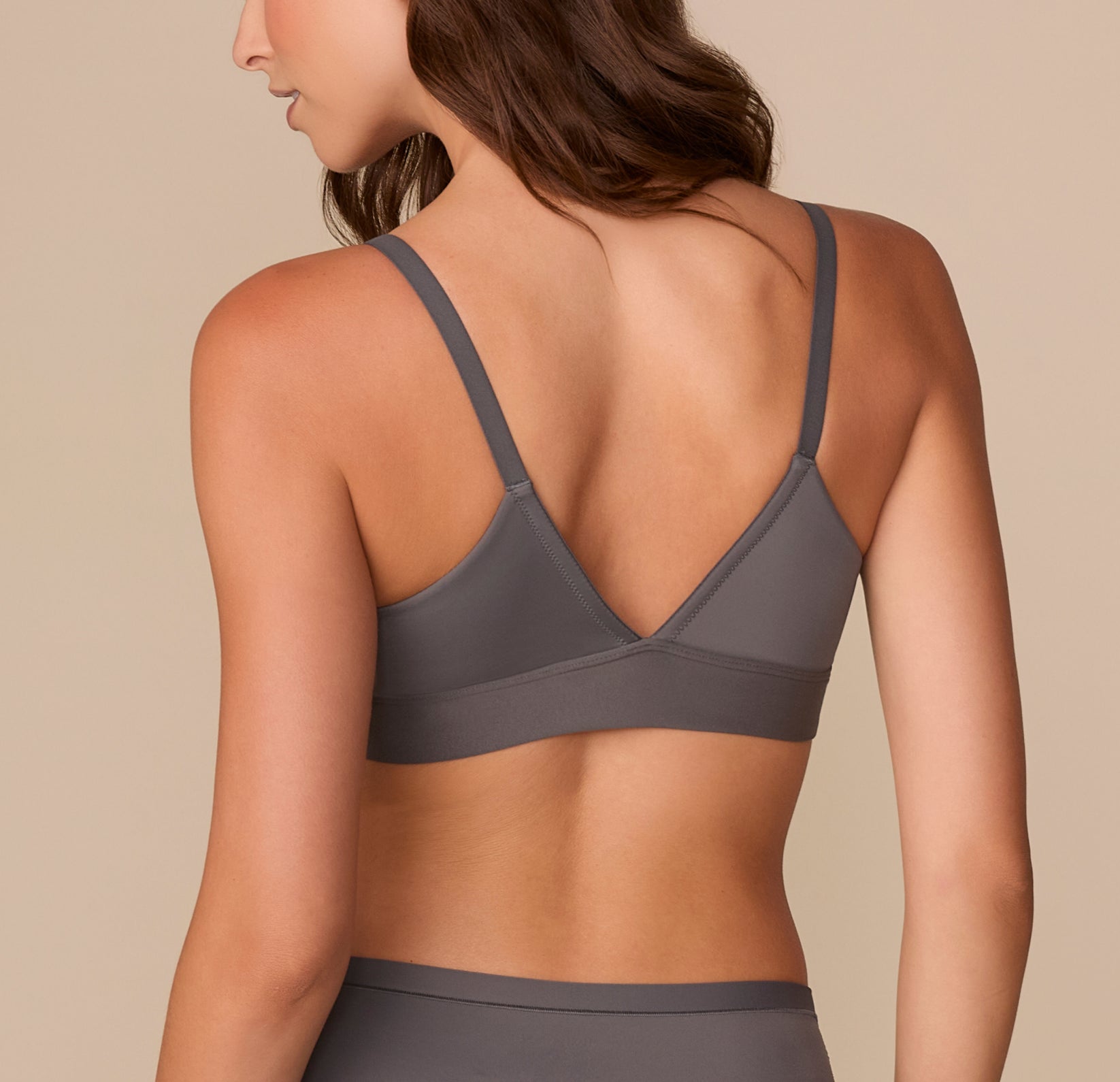Back view of Alexis in the Bliss Triangle Bralette in Smoke, highlighting the V-shaped back and seamless design for all-day comfort.