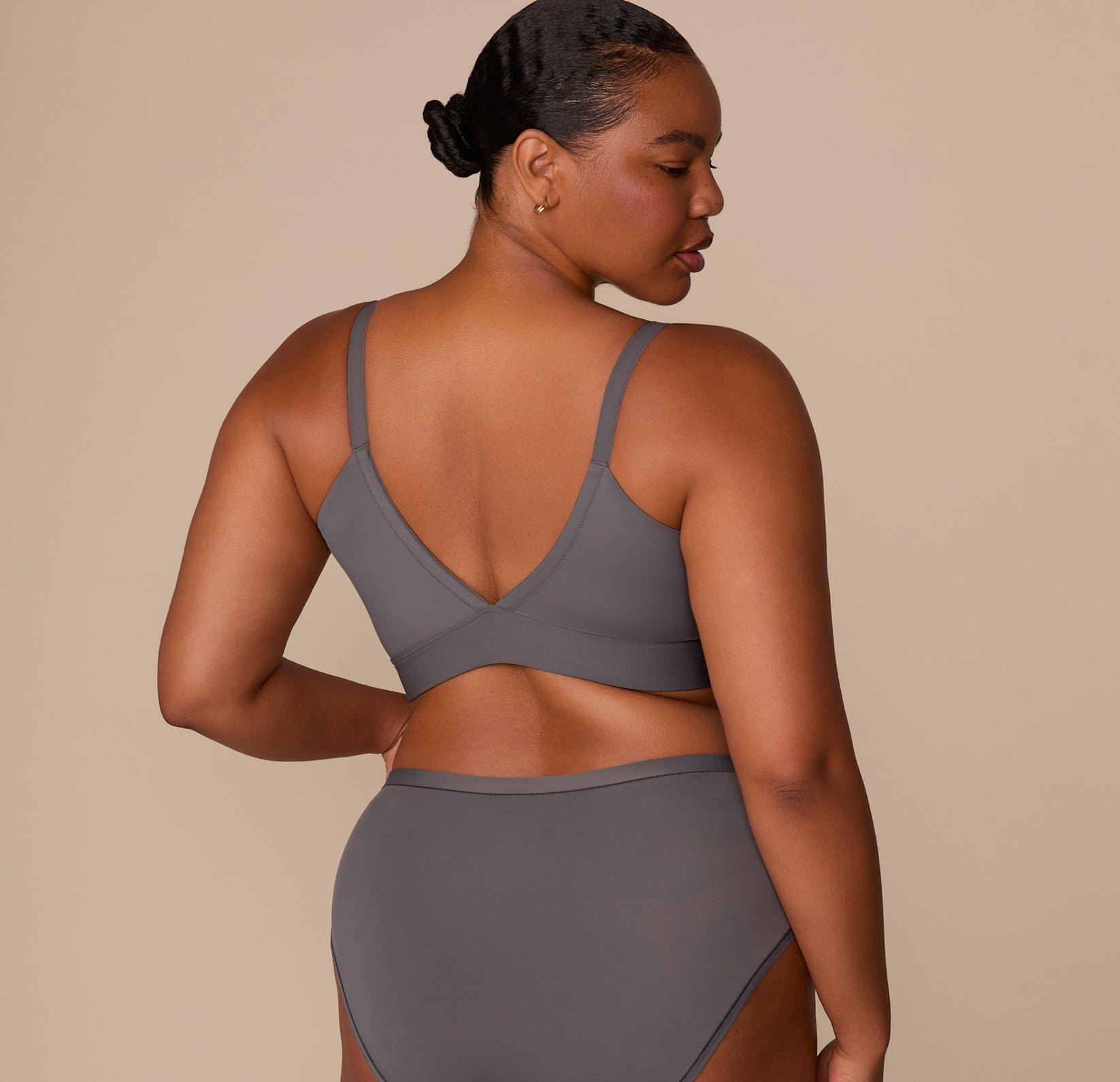 Back view of Zarria modeling the Bliss Triangle Bralette in Smoke, showing the smooth fit and wider straps designed for larger sizes.