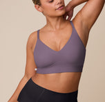 India poses in the Bliss Triangle Bralette in Eclipse paired with the Bliss Boyshort in Black, facing slightly sideways with her hand behind her head. The bralette’s shaping and soft structure are shown in contrast with the high-rise black boyshort. sizing: India wears size XL