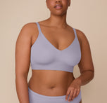 Zarria faces forward, showcasing the front of the Bliss Triangle Bralette and Bliss Hiphugger in Violet. The bralette has a smooth, seamless appearance with a plunging neckline and supportive underband. Adjustable straps and clean finishing create a sleek silhouette. sizing: Zarria wears size 2XL
