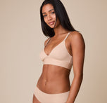 A three quarter profile of Ally in the Bliss Triangle Bralette in Beige, showing the seamless design and flexible fit that moves with the body.