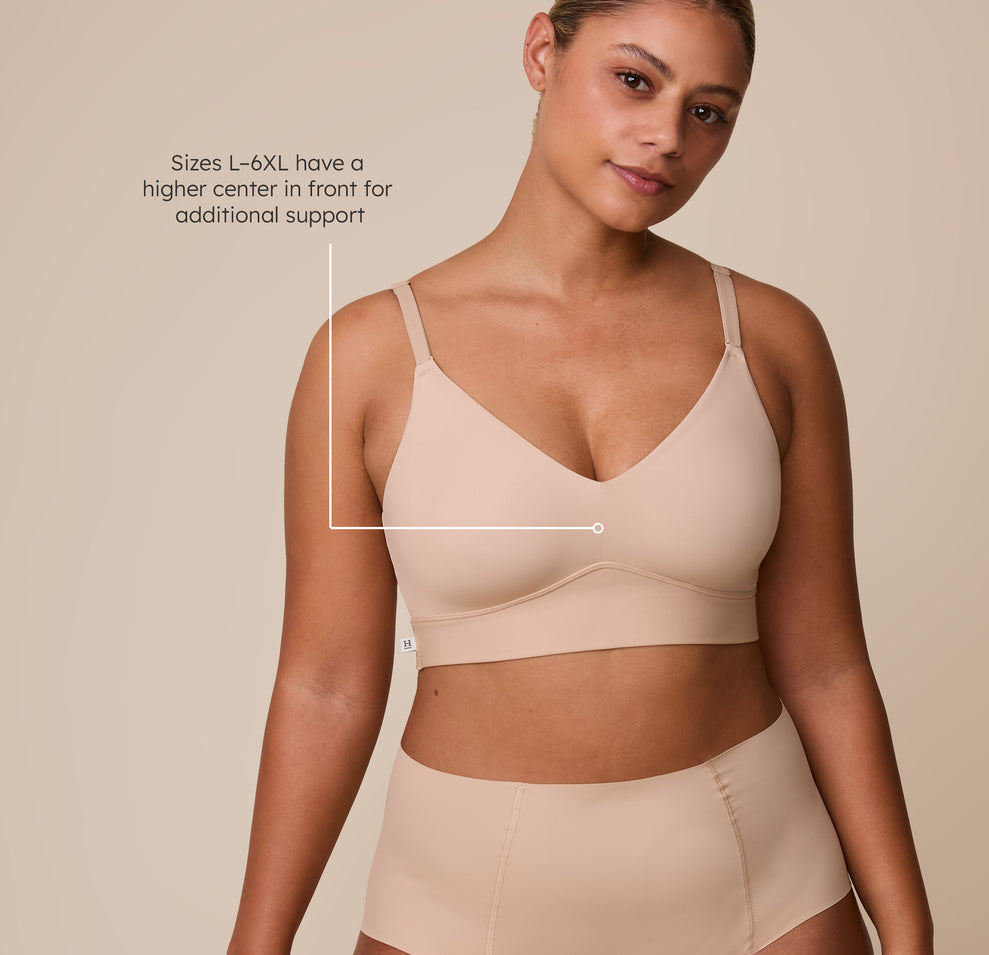 A close-up of India wearing the Bliss Triangle Bralette in Beige, featuring a fit callout for sizes L-6XL, which have a higher center front for additional support. sizing: India wears size Large