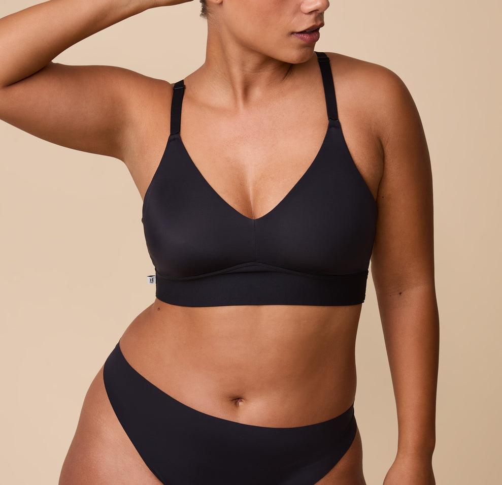 A close-up of India wearing the Bliss Triangle Bralette in Black. The deep V-neckline and ultra-soft fabric highlight the bralette’s effortless, lightweight design. sizing: India wears size Large