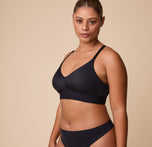 India poses in the Bliss Triangle Bralette in Black, emphasizing its wireless, unpadded construction for all-day comfort.