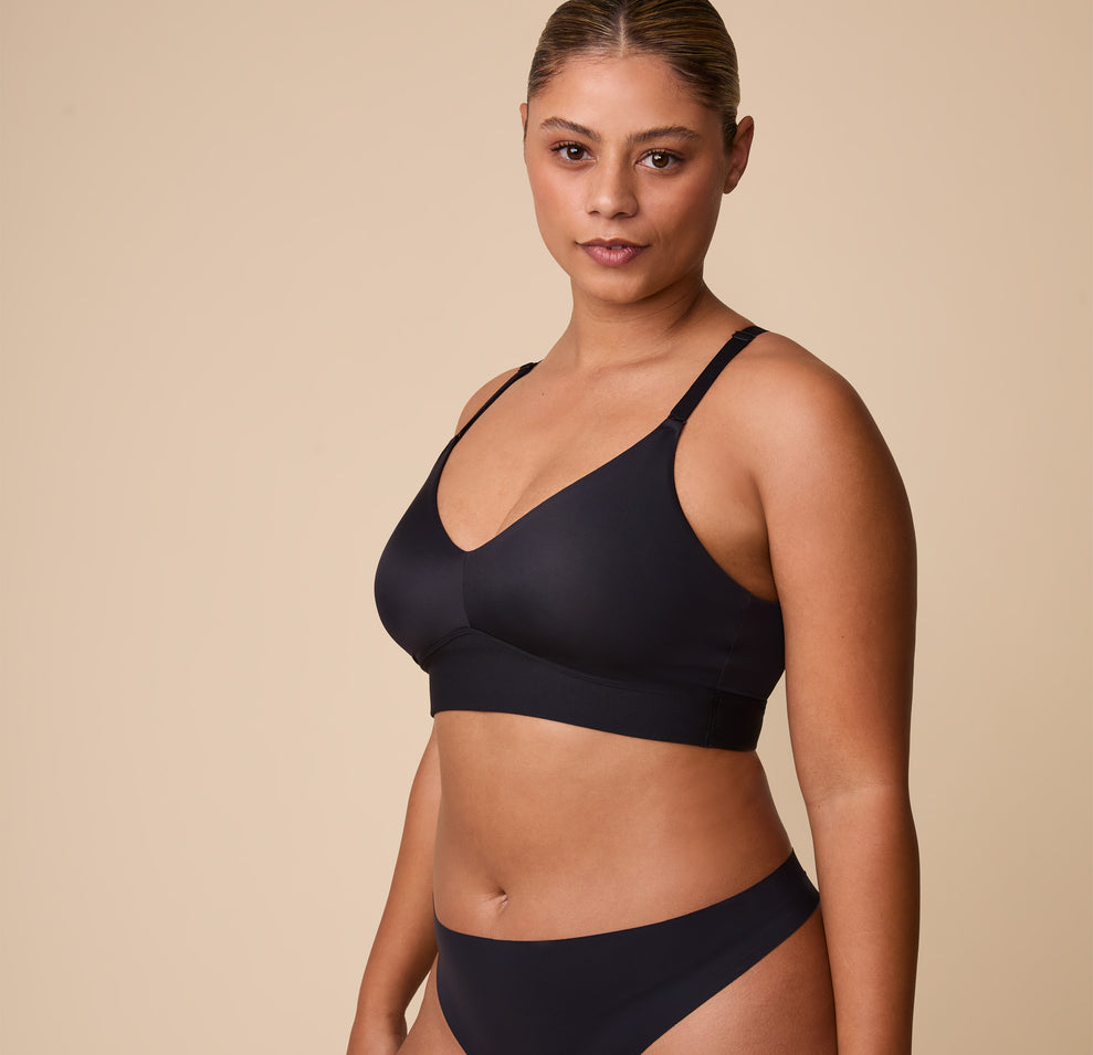 India poses in the Bliss Triangle Bralette in Black, emphasizing its wireless, unpadded construction for all-day comfort.