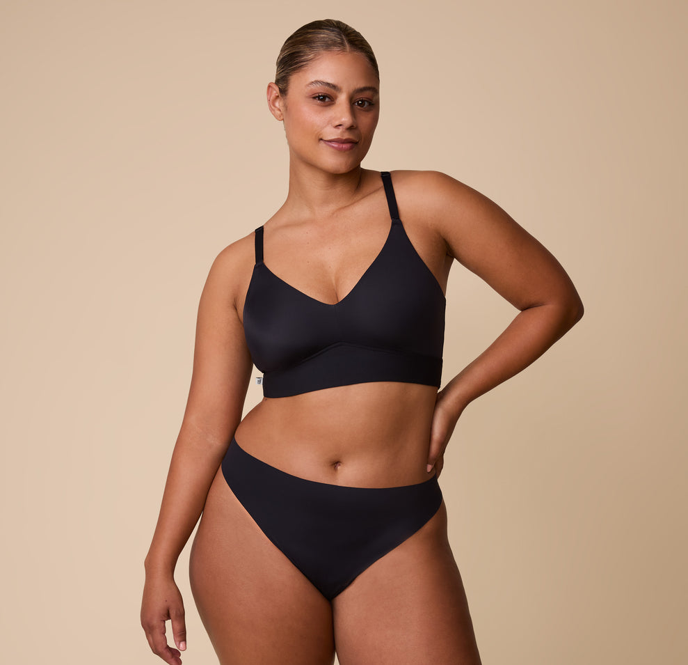 India models the Bliss Triangle Bralette in Black with the matching Bliss Bikini, showcasing the smooth, seamless fit of the set.
