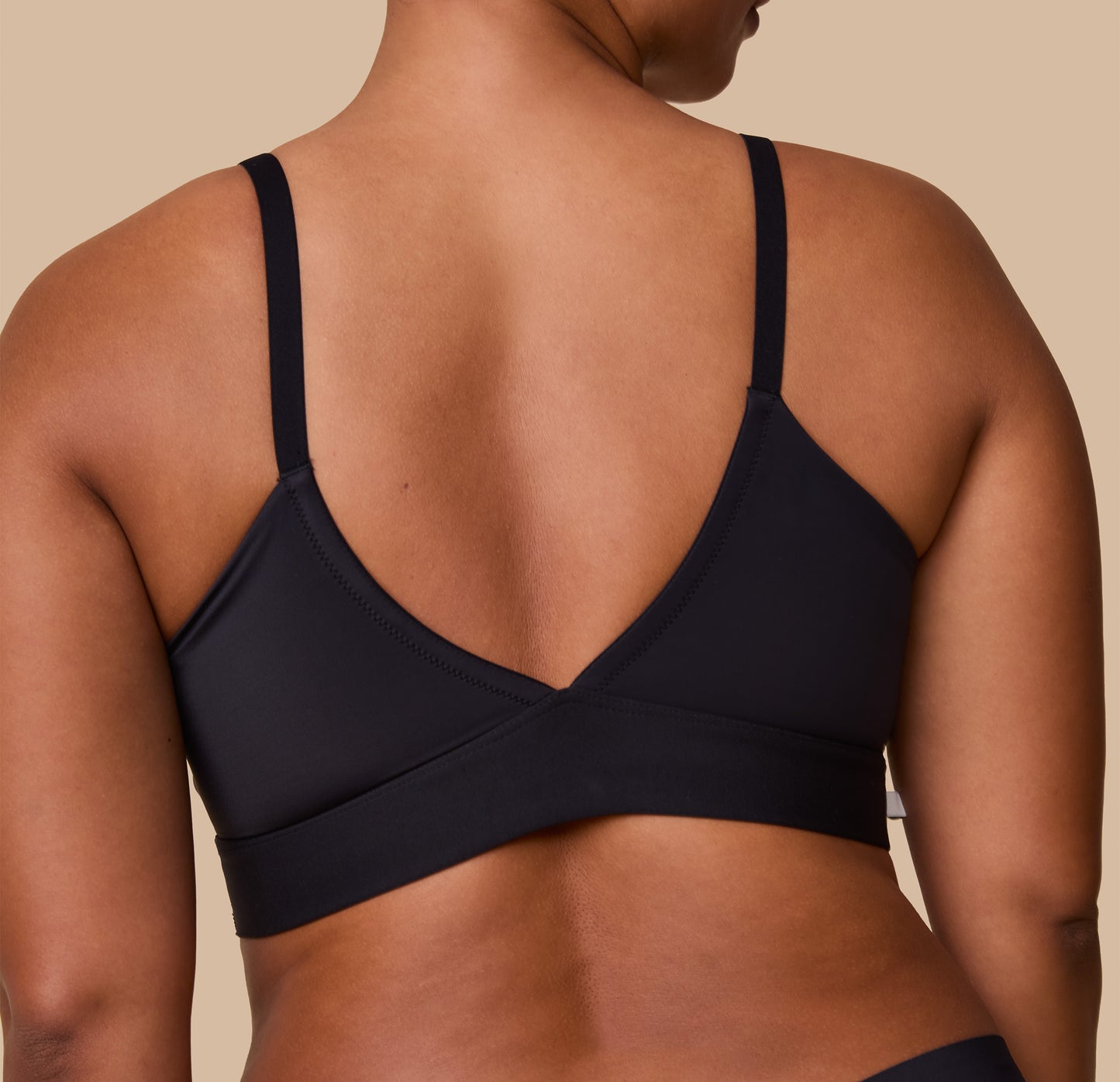 A detailed back view of the Bliss Triangle Bralette in Black, focusing on the low-cut V-back and soft, stretch fabric.